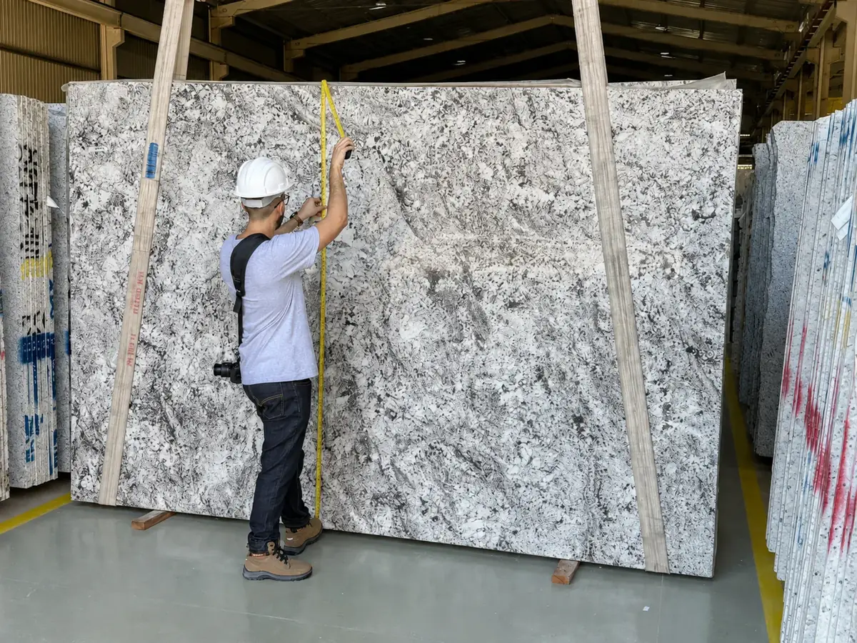 Inspector measuring a natural stone slab during an on-site verification
